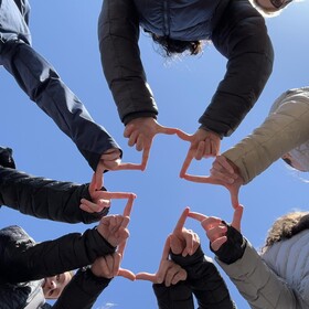 élèves faisant une croix avec leurs doigts, photo prise de dessous
